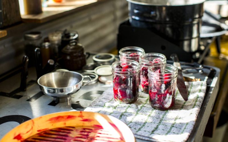 Preserves jars of beetroot on tea towel in kitchen