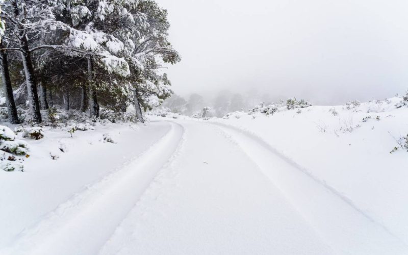 Traces of the tire tracks of a car on snow on a hilly road.